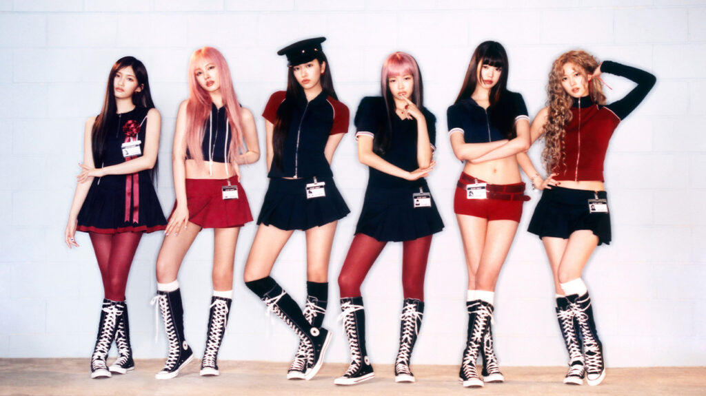 K-pop group IVE posing in black, white and red clothing against a wall.